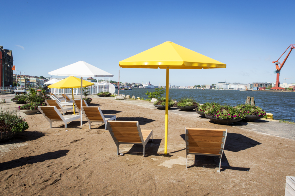 Solstolar, parasoller och konstgjordsandstrand vid Playa Skeppsbron.