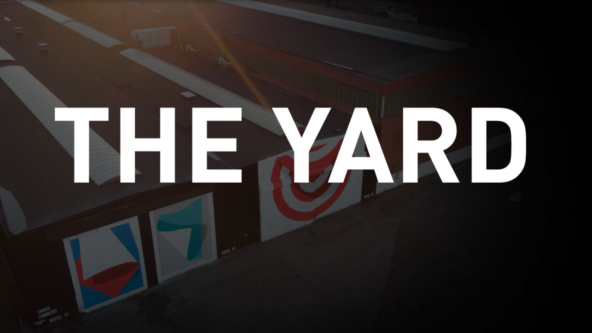 Logotyp för The Yard med en mörktonad bild från eventytan med pågående event.